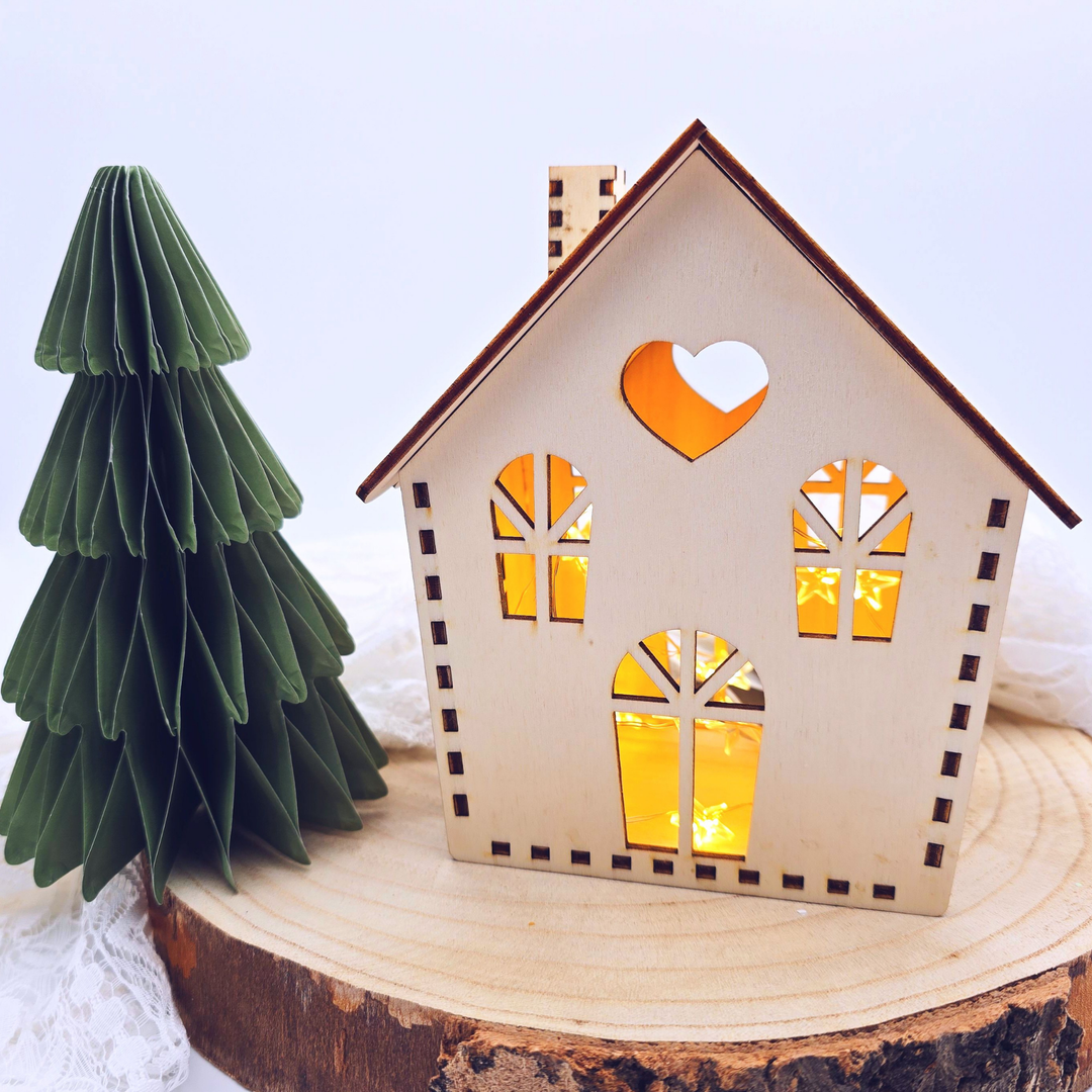 Holzhaus mit Herz und Fenstern, beleuchtet mit warmem Licht – handgefertigte Weihnachtsdeko aus Holz für Tisch oder Fensterbank.