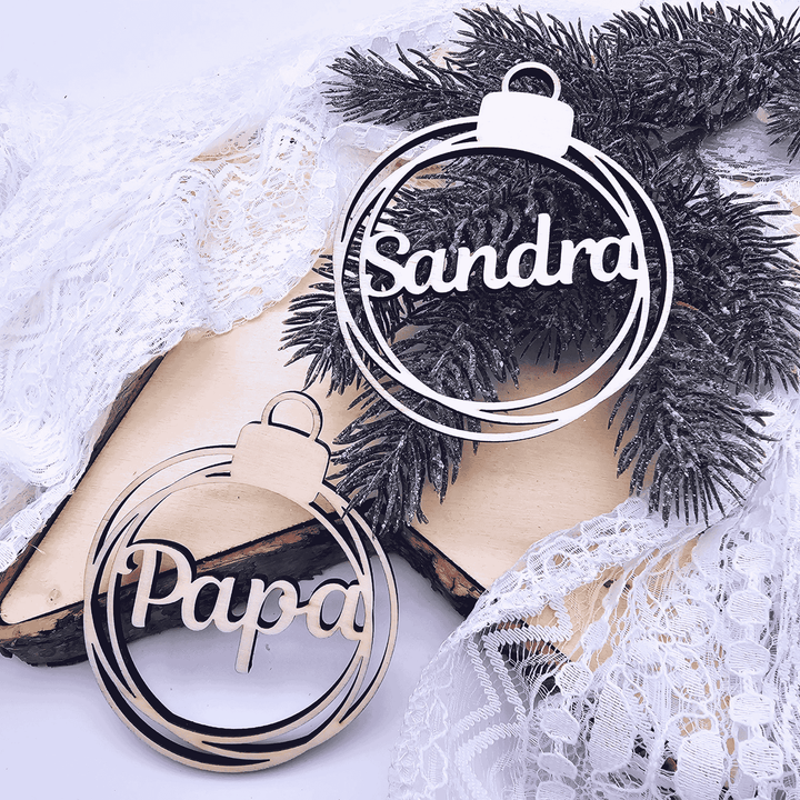 Weihnachtskugel aus Holz mit ausgeschnittenem Namen – festliche Tischdeko oder Geschenkanhänger.